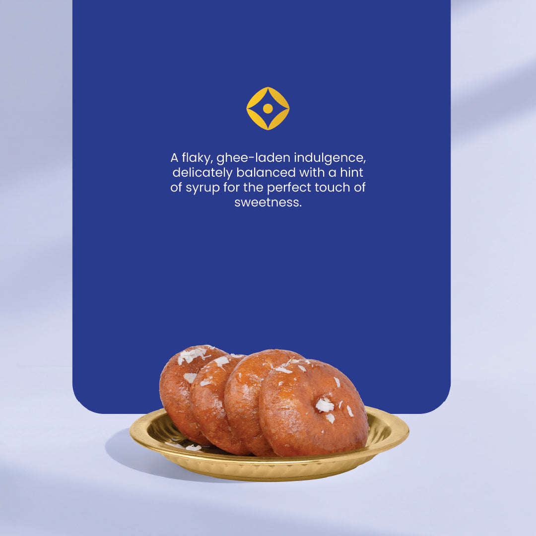 Three badushahs (indian sweet) on a gold plate with a blue background and text describing the sweets